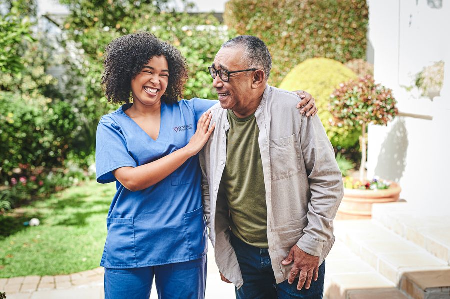 A SYNERGY HomeCare caregiver strolling through the garden with a client