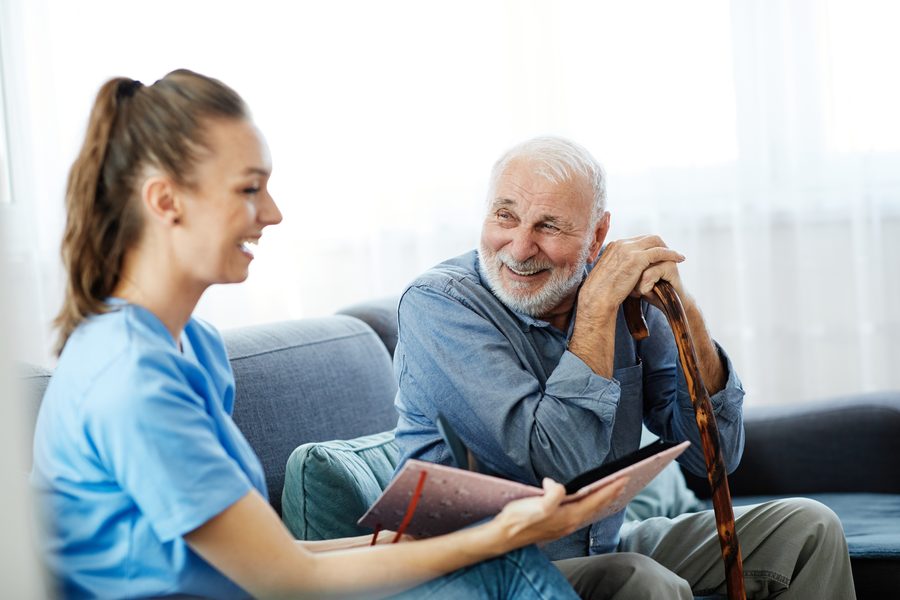 A SYNERGY HomeCare caregiver visiting with a client at home
